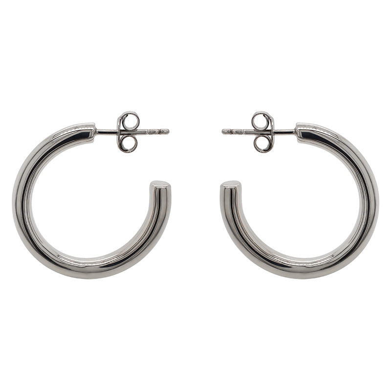 These modern, thick hoop earrings are made of solid sterling silver. The 26 mm hoops are displayed side facing on a marbled background.
