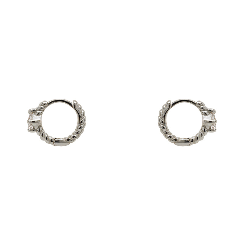 
                  
                    Load image into Gallery viewer, A pair of twist pattern style huggie earrings with princess cut crystals made of sterling silver. Displayed side facing on a white background.
                  
                