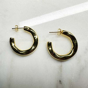 
                  
                    Load image into Gallery viewer, 3/4 organic style hoop earrings with posts made of 14 kt yellow gold vermeil on an ivory colored tile.
                  
                