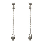 A pair of milgrain, bezel set round crystal studs with a smaller hanging bezel set crystal and chain connected to the earring back, and made of 925 sterling silver.