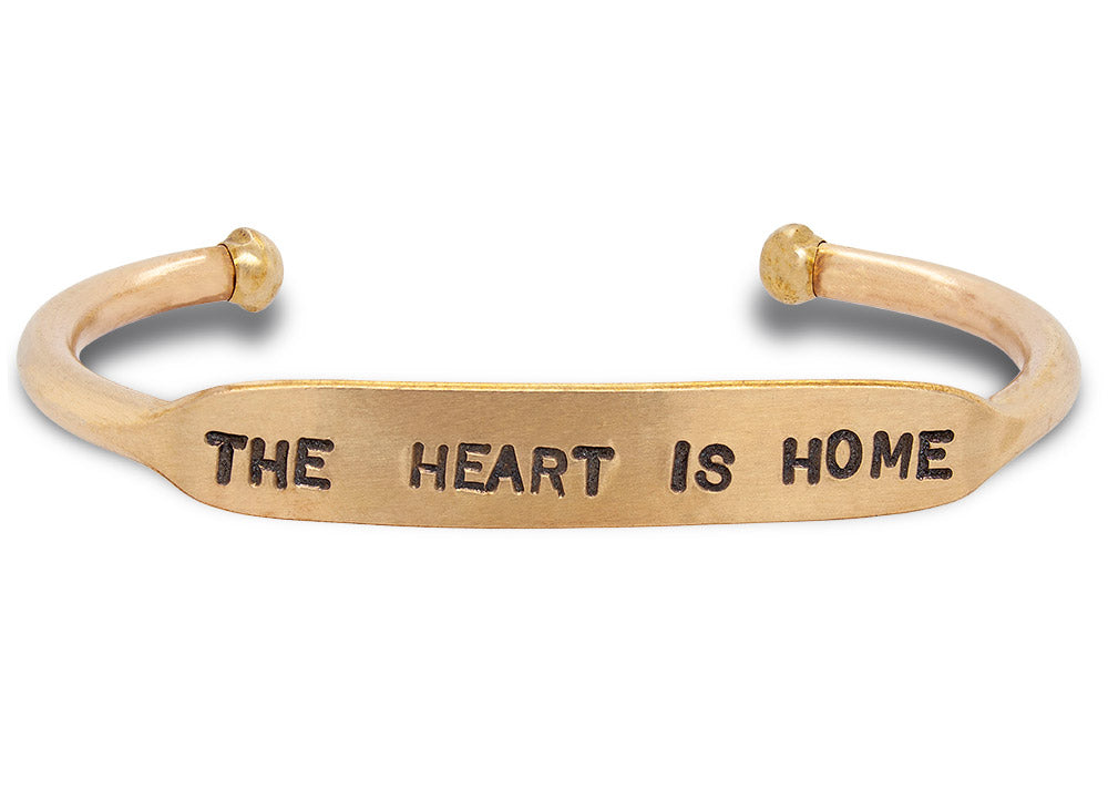 Hand stamped, solid brass cuff that says 