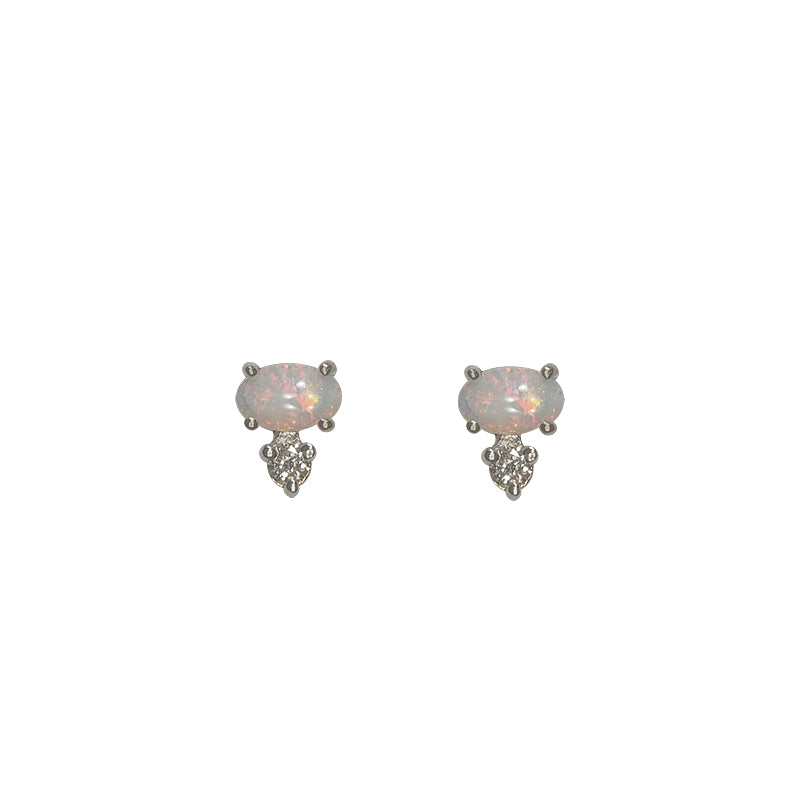 Front view of white oval opals, set east-west in 14 kt white gold with 1 round accent diamond set vertically below each. Displayed on white background.