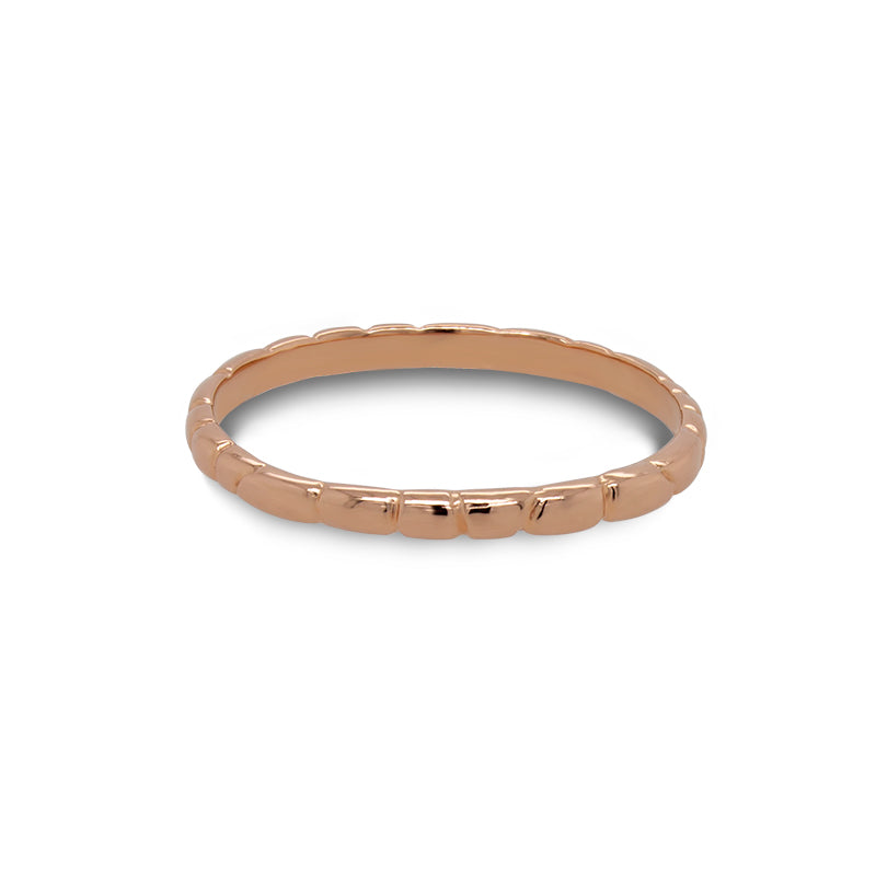Front view of a stacking band with organic spaced lines casted in 14 kt rose gold. 