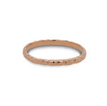 Front view of a stacking band with organic spaced lines casted in 14 kt rose gold. 