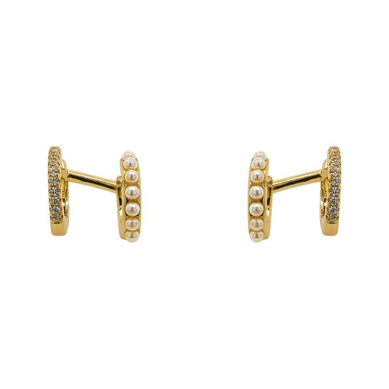One pair of 14 kt yellow gold vermeil double ear hugger ear cuffs. Adorned with pearls on one side and crystals on the other. Displayed front facing on a marble background.