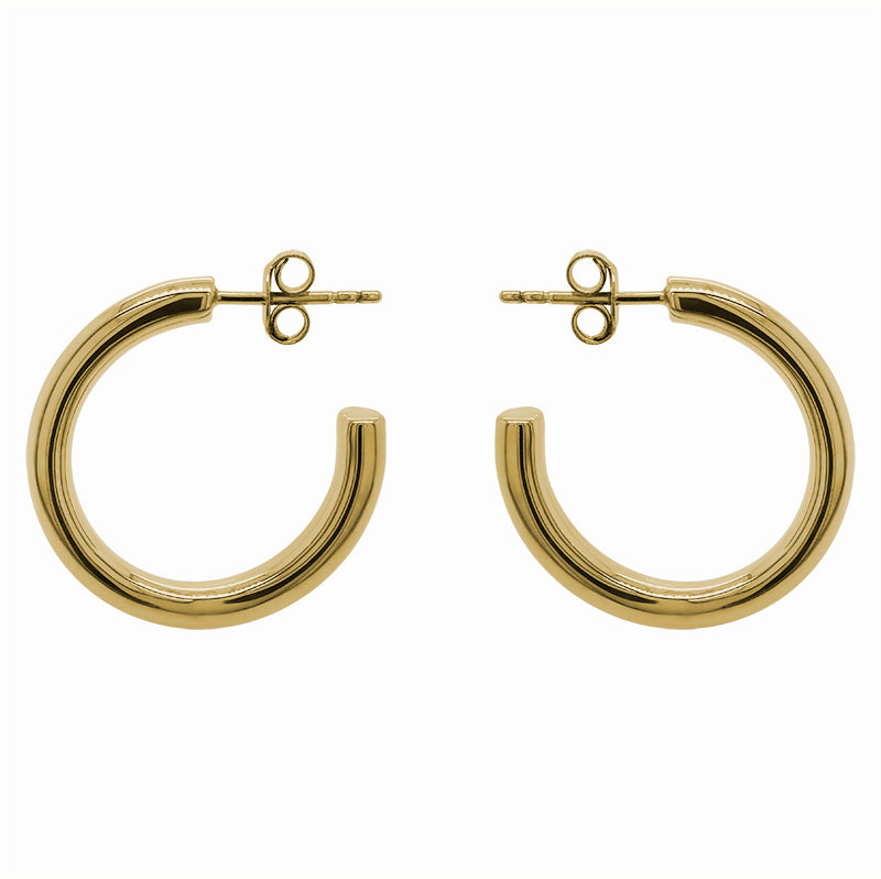 These modern, thick hoop earrings are made of 14 kt yellow gold vermeil. The 26 mm hoops are displayed side facing on a marbled background.