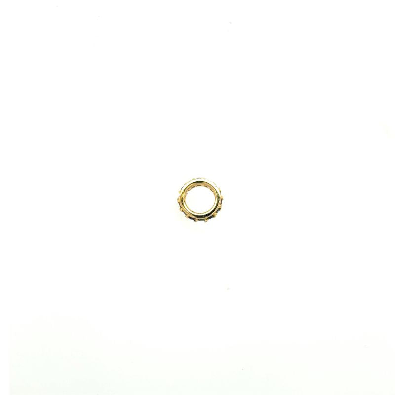 A side photo of a yellow gold and deep blue sapphire spacer on a white background.