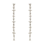 A pair of 925 sterling silver drop earrings with round, pear and marquise cut crystals in front of an ivory colored tile background.