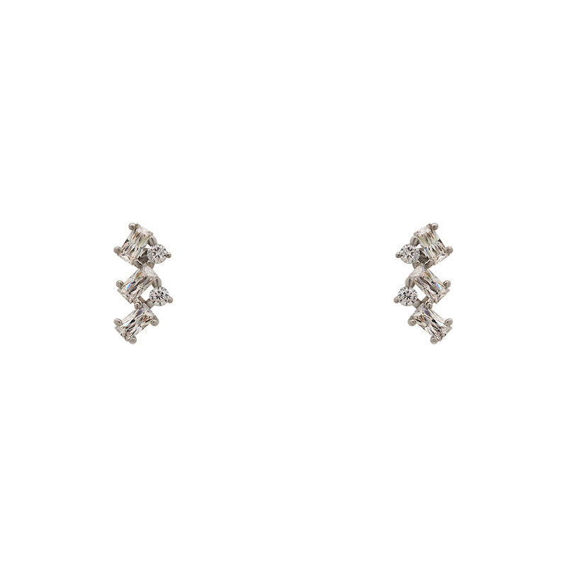 A pair of crystal cluster studs with 2 round cut and 3 baguette cut crystals set in 925 sterling silver settings on a white background.