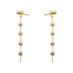 These pearl earrings are made of 925 sterling silver with 14 kt yellow gold vermeil. The earrings drop 65 mm from top to bottom. Displayed side facing on a marble background.