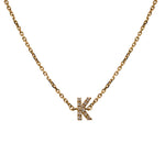 A 14 kt yellow gold cable style chain bracelet with a diamond encrusted letter K on a white background.