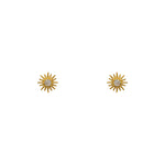 Tiny starburst studs made of 14 kt yellow gold vermeil with round crystal centers on a white background.