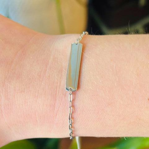 Sterling silver long bar shown on a woman's right wrist with a paperclip chain attached to both sides.