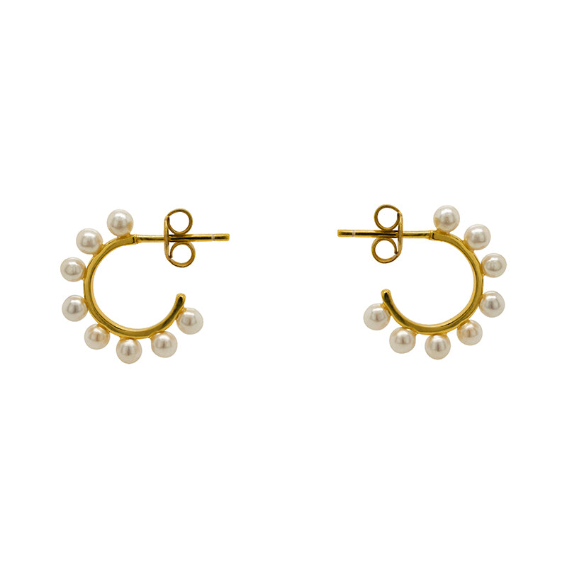 These 3/4 wire hoop earrings are made of 925 sterling silver with 14kt yellow gold vermeil. Each hoop is adorned with 8 pearls and measure at 17.25 mm. Displayed side facing on a marble background.