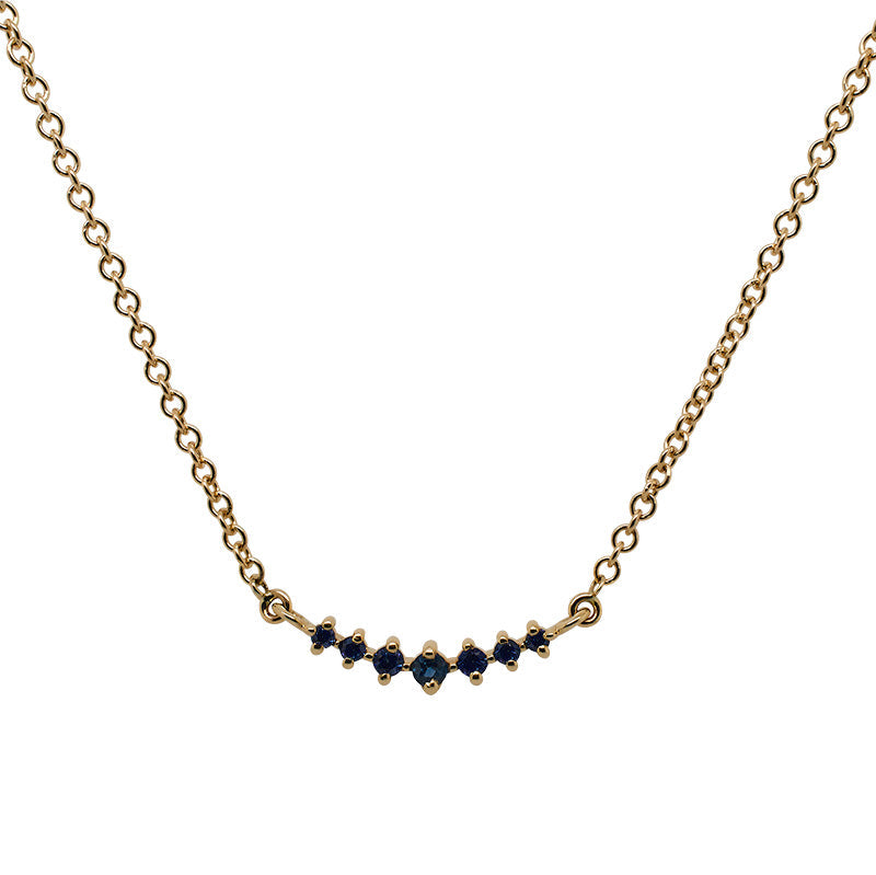 Front view of a graduated, blue sapphire necklace with 7 round cut sapphires set in 14 kt yellow gold.