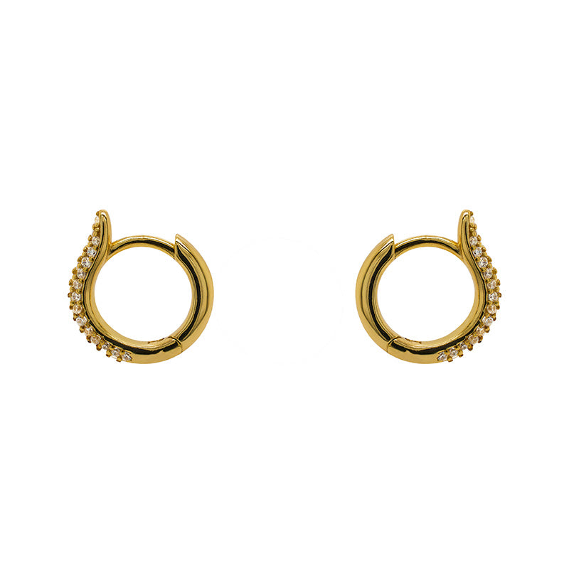 Huggie style earrings made of 14kt yellow gold vermeil and completely encrusted with tiny, 1 mm crystals. Displayed side facing on a white background.