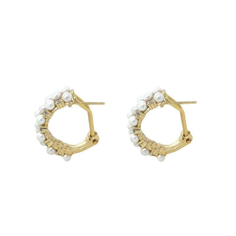 A side view of yellow gold hoops with crystals and pearls shown on a white background.