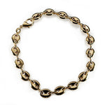 Overview of a large gold filled mariner link style anklet on a white background.