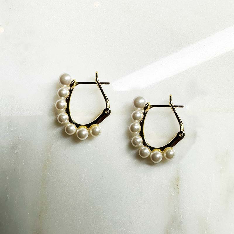 14 kt yellow gold vermeil ear hugger earrings with pearls on an ivory colored tile.