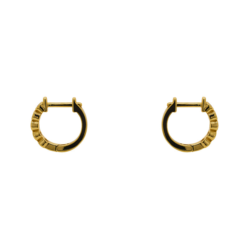 A pair of huggie style earrings with 2 mm bezel set crystals and a 14 kt yellow gold vermeil setting. Displayed side facing on a white background.