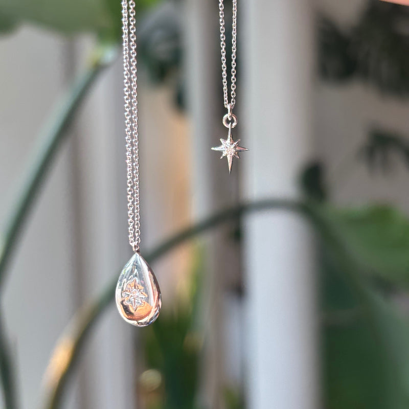 
                  
                    Load image into Gallery viewer, A classic North Star pendant necklace is made of solid 14 kt gold, with a round diamond set in the middle.
                  
                