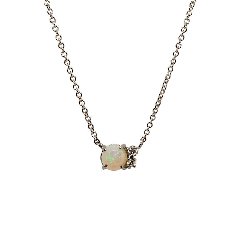 A Cabochon opal cluster necklace with two round cut diamonds cast in 14 kt white gold.