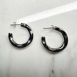 3/4 organic style hoop earrings with posts made of 925 sterling silver on an ivory colored tile.