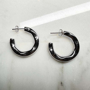 
                  
                    Load image into Gallery viewer, 3/4 organic style hoop earrings with posts made of 925 sterling silver on an ivory colored tile.
                  
                