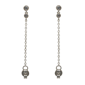 
                  
                    Load image into Gallery viewer, A pair of milgrain, bezel set round crystal studs with a smaller hanging bezel set crystal and chain connected to the earring back, and made of 925 sterling silver.
                  
                