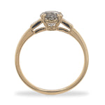 Side view of a round cut salt and pepper diamond ring flanked by 2 baguette cut diamonds, and cast in 14 kt yellow gold.