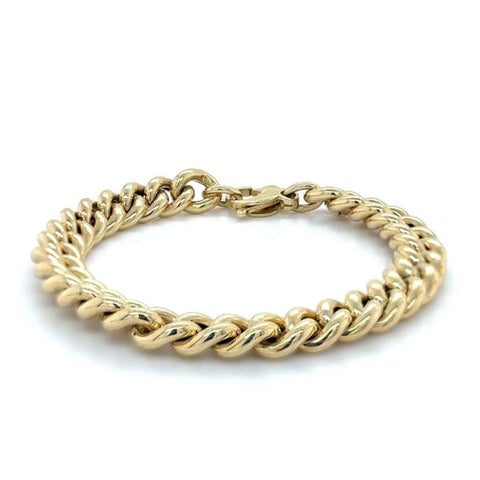A large curb chain bracelet in yellow gold shown on a white background.