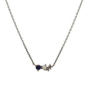 
                  
                    Load image into Gallery viewer, Front view of an asymmetrical cluster necklace set with a round cut blue sapphire, one cabochon opal and two round diamonds. Set in 14 kt white gold.
                  
                
