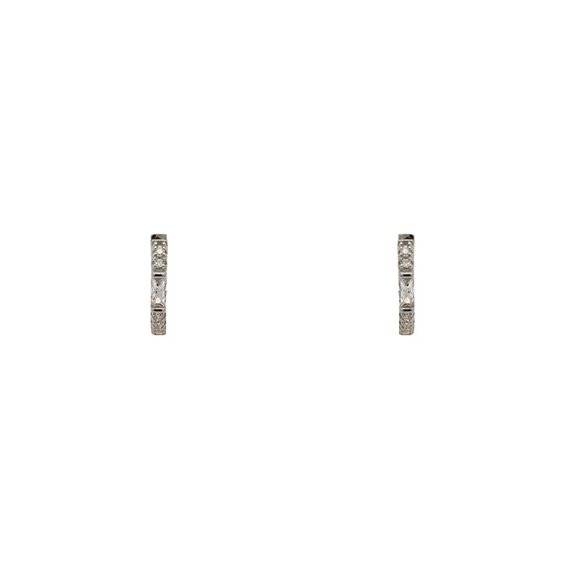 
                  
                    Load image into Gallery viewer, A pair of huggie style earrings with round and baguette crystals in a sterling silver setting. Displayed forward facing on a white background.
                  
                
