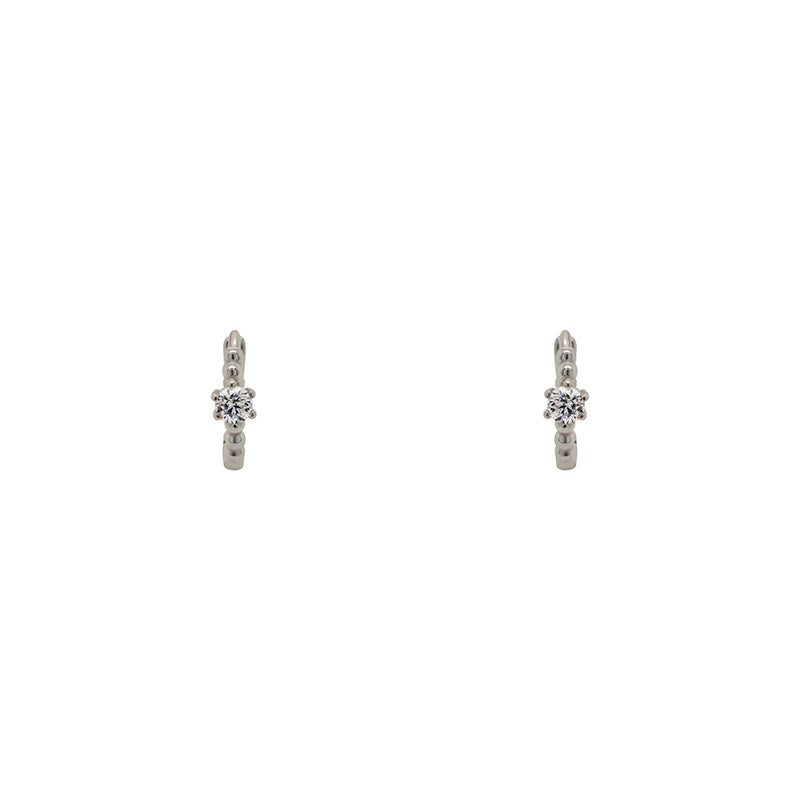 A pair of huggie style earrings each with a dot pattern and 2.5 mm crystal and made of sterling silver. Displayed forward facing on a white background.