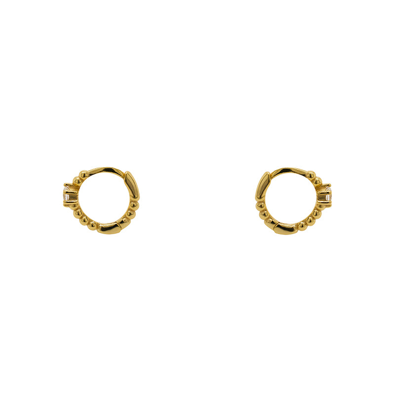 
                  
                    Load image into Gallery viewer, A pair of huggie style earrings each with a dot pattern and 2.5 mm crystal and made of 14 kt yellow gold vermeil. Displayed side facing on a white background.
                  
                