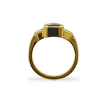 Through the finger view of an emerald cut, green sapphire and Cadillac cut diamond ring cast in 18 kt yellow gold.