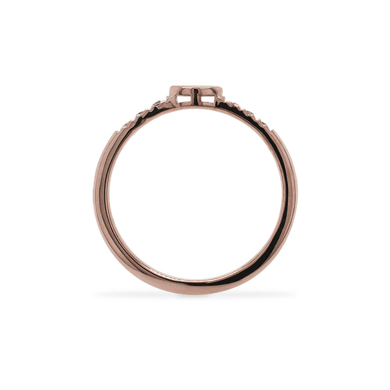 
                  
                    Load image into Gallery viewer, Through the finger view of a 14 kt rose gold ring with an east west, bezel set marquise diamond in the center and 3 smaller, round diamonds on either side.
                  
                
