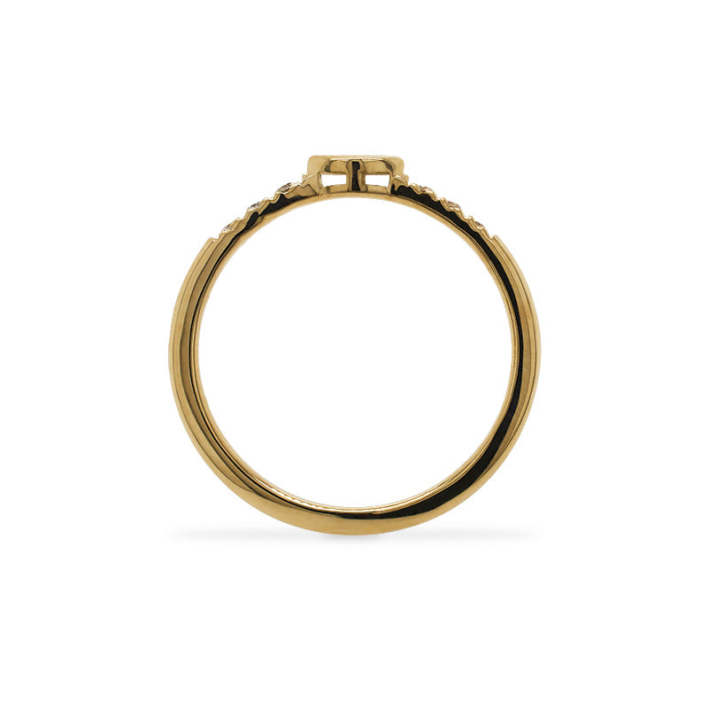 
                  
                    Load image into Gallery viewer, Through the finger view of a 14 kt yellow gold ring with an east west, bezel set marquise diamond in the center and 3 smaller, round diamonds on either side.
                  
                