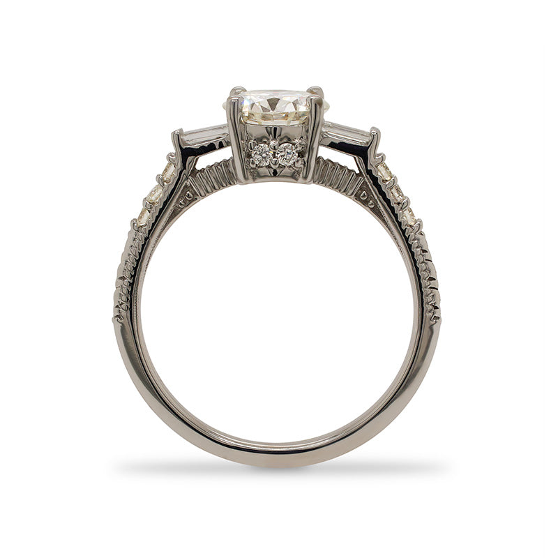 
                  
                    Load image into Gallery viewer, Side view of a round cut diamond engagement ring made of 14 kt white gold with baguette and round cut diamonds going down the shank and two additional round cut diamonds on the side.
                  
                