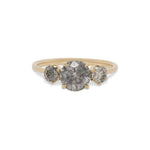 Front view of a salt and pepper diamond ring with one large, round center stone between 2 smaller round stones cast in 14 kt yellow gold by King + Curated.