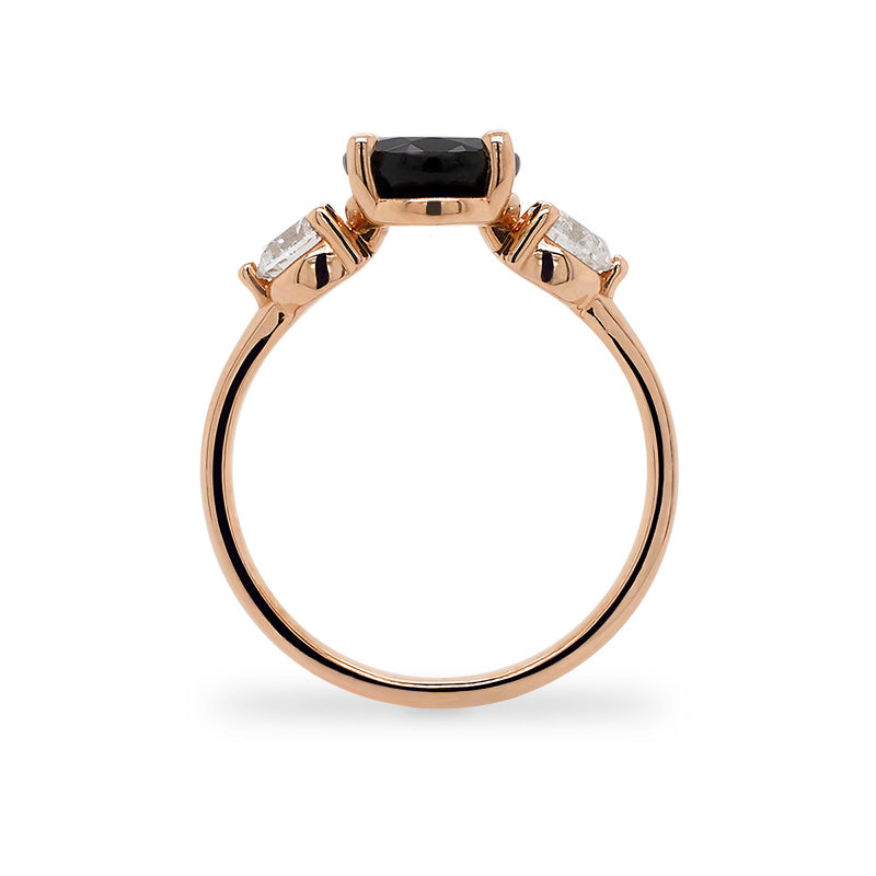 Side view of oval cut black sapphire and round cut diamond ring set in 14 kt rose gold.