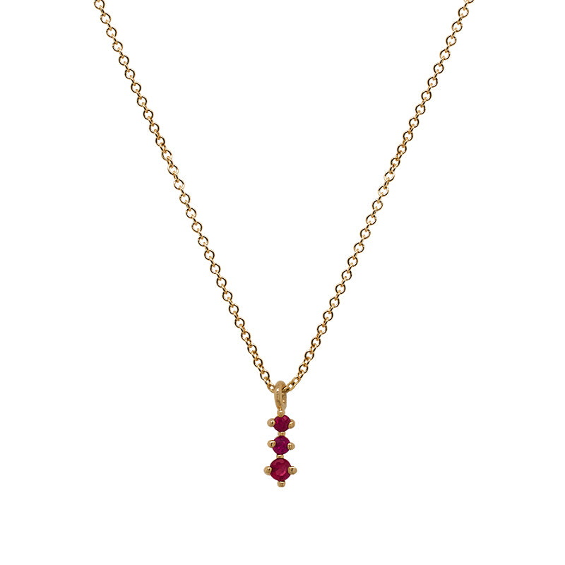 A dainty 14 kt yellow gold necklace with a pendant that has 3 small, round cut rubies in a north south setting on a white background.