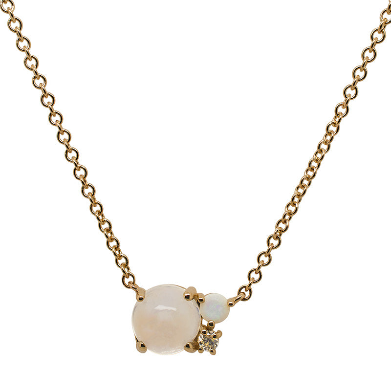 Front view of an asymmetrical moonstone, opal and round cut diamond cluster necklace cast in 14 kt yellow gold.