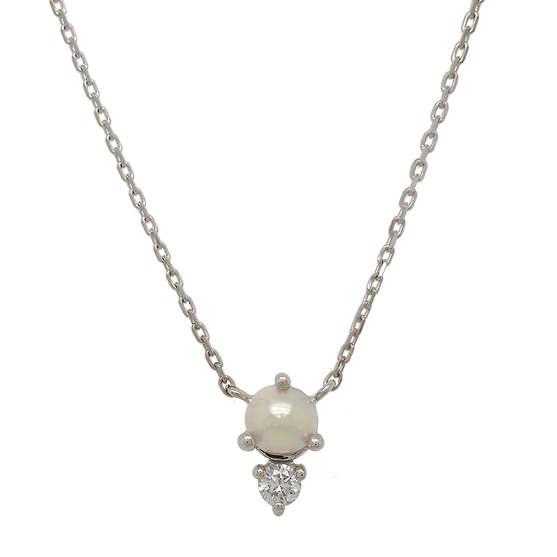 Front view of a cabochon pearl and round cut diamond necklace cast in a 14 kt white gold north-south setting.