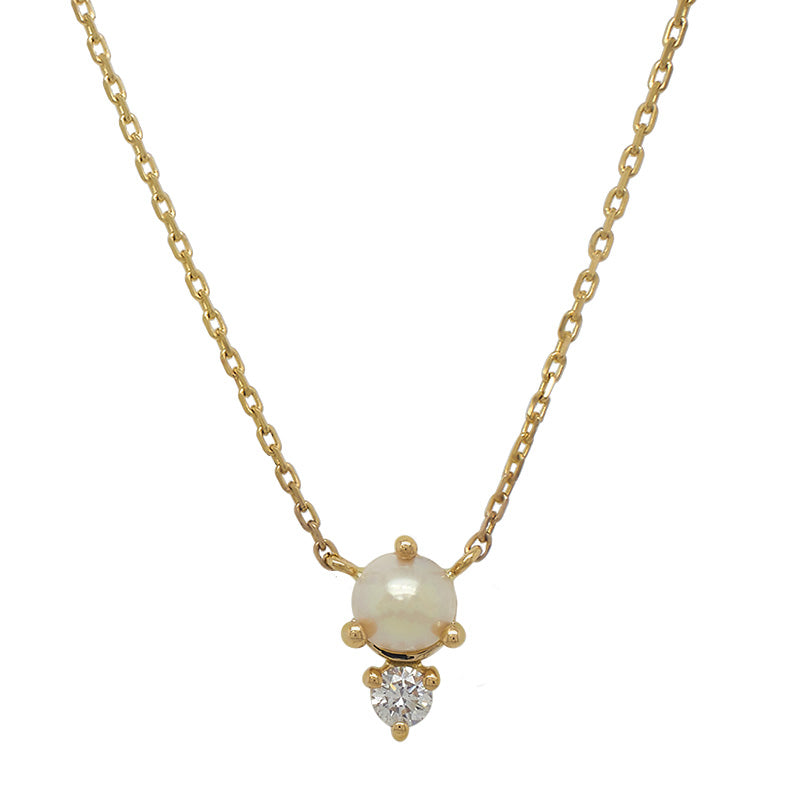 Front view of a cabochon pearl and round cut diamond necklace cast in a 14 kt yellow gold north-south setting.