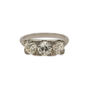 
                  
                    Load image into Gallery viewer, Front view of an Edwardian Deco style ring with 1 old euro cut center diamond set between 2 old mine cut diamonds. The ring is cast in platinum with a vintage style engraving going down the band.
                  
                