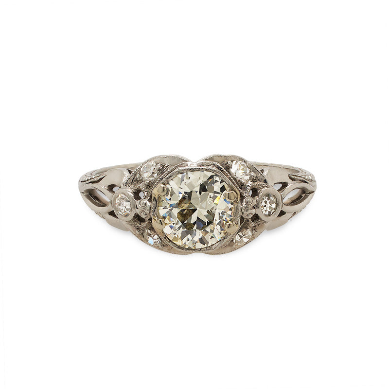
                  
                    Load image into Gallery viewer, Front view of an Edwardian Deco style ring with 1 old euro cut center diamond set among 6 single cut diamonds. The ring is cast in platinum with a vintage style engraving going down the band.
                  
                