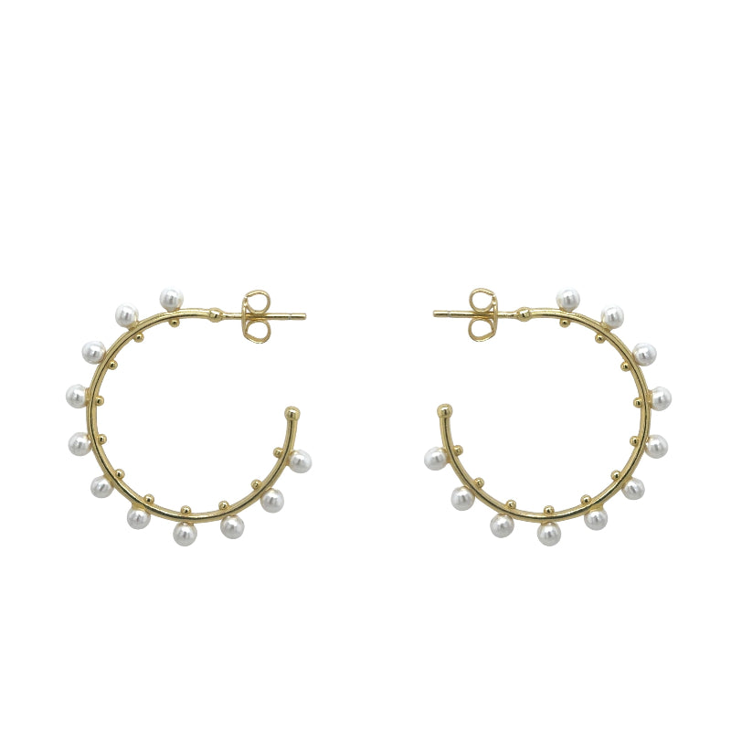 A side view of yellow gold pearl hoops shown on a white background.