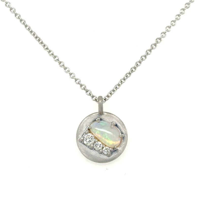 A front view of a white gold pendant with an opal and three round diamonds shown on a white background.