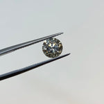 Front view of a 1.25 ct. round salt and pepper diamond in tweezers.